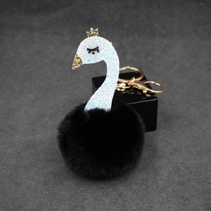 Detail of creative swan plush keychain with black pompom and gold sequin neck