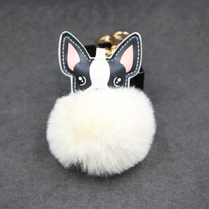 Detail eines süßen Leder-Hund Schlüsselanhängers mit weißem Pompon und Goldverschluss