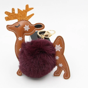 Detail of Christmas reindeer keychain with brown PU leather, gold antlers and purple pompom