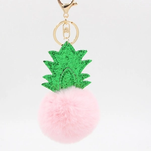 Detail of pink faux fur pom pom keychain with green sequined pineapple leaves