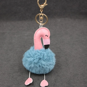Détail de la tête de flamant en similicuir rose et pompon en fausse fourrure bleue sur doré
