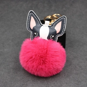 Nahaufnahme von süßem Hunde-Pelzkugel-Schlüsselanhänger mit rosa Kunstpelz und Goldring