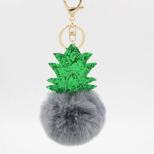Detailed view of the pineapple plush keychain with green sequins and grey faux fur pompom