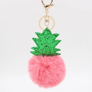 Detail of pink plush pineapple keychain with green glitter leaves and golden metal clasp