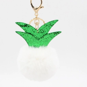 Detailed view of pineapple plush keychain with white faux fur pompom and green sequins