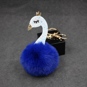 Detailed view of royal blue plush swan keychain with golden hardware and glitter crown