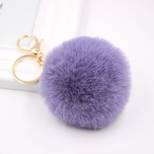 Detail of soft purple faux fur pompom keychain with premium golden metal lobster clasp