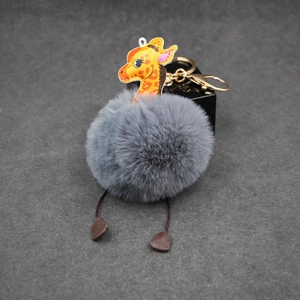 Gray fluffy giraffe keychain with golden metal ring and brown leather accents