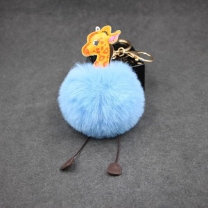 Blue faux fur giraffe keychain with gold metal clasp and soft pompom bag charm