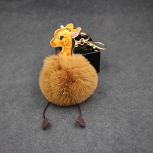 Giraffe pom-pom keychain with fluffy brown fur ball and golden metal lobster clasp charm