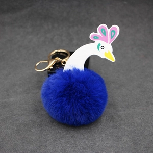 Détails du porte-clés pompon paon avec son fermoir mousqueton doré et anneau métallique