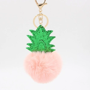 Creative pineapple plush keychain with pink fur ball and green glitter leaves on white backdrop