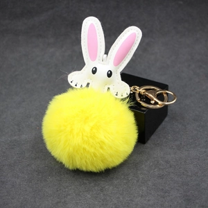 Detailed view of yellow faux fur rabbit keychain with soft texture and golden metal clasp