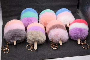 Détail de porte-clés pompon glace coloré avec fermoirs mousquetons en métal doré