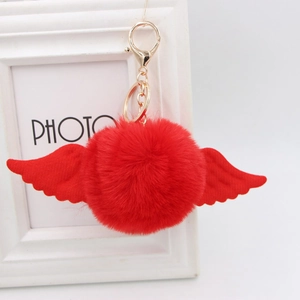 Detail of red plush ball keychain with angel wings and gold lobster clasp