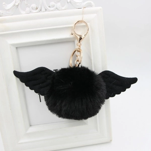 Detail view of black faux fur pompom keychain with wings and a gold lobster clasp