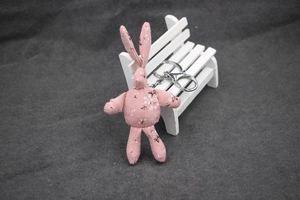 Gros plan d'un porte-clés lapin en tissu rose fleuri avec mousqueton en métal argenté