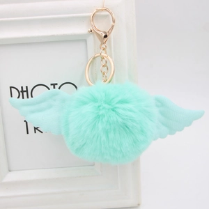 Close-up of mint green faux fur pompom keychain with angel wings and gold clasp