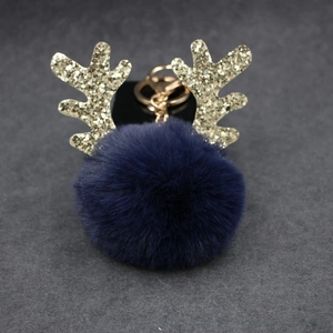Detail of Christmas reindeer keychain with navy faux fur ball and gold glitter antlers