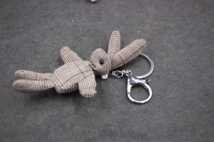 Détail du porte-clés lapin en peluche à carreaux marron avec son fermoir mousqueton en métal