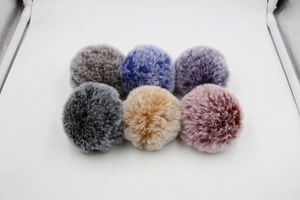 Detailed view of six colorful 8cm faux fur pompom charms for bags and accessories
