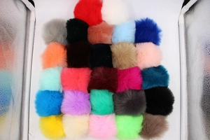 Macro view of various colorful faux fur pom-poms showing thick texture and diverse shades