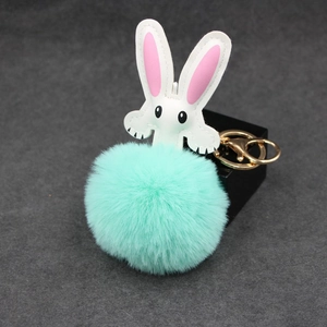 Detail of mint green plush fur bunny keychain with white leather ears and gold lobster clasp