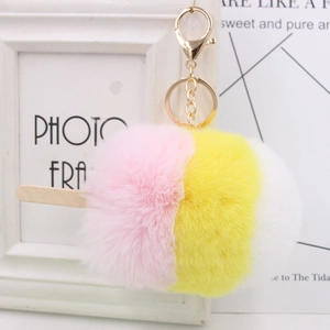 Détail d'un porte-clés glace en peluche tricolore avec fermoir doré et bâtonnet en bois