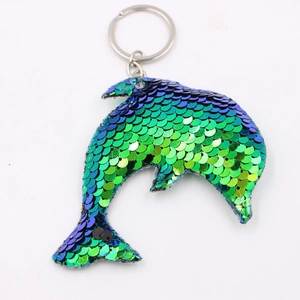 Dettaglio del portachiavi a delfino in paillettes reversibili blu e viola con anello