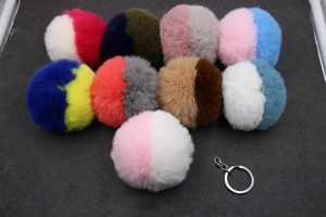 Détail de porte-clés pompon en fausse fourrure bicolore avec anneaux en métal argenté