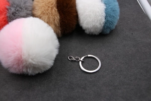 Vue détaillée du pompon bicolore en fausse fourrure avec porte-clés en alliage de zinc