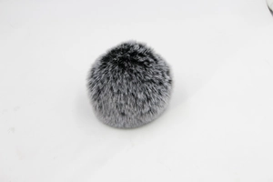 Detailed close-up of a fluffy two-tone black and silver grey faux fur pom-pom ball