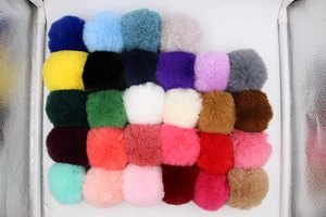 Flat lay view of colorful faux fur pom-poms in various vibrant shades for DIY accessories