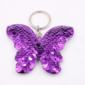 Dettaglio del portachiavi a farfalla con paillettes viola e riflessi metallici lucidi