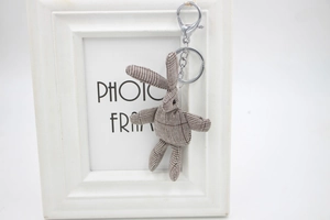 Détail d'un pendentif lapin en peluche à carreaux avec porte-clés et fermoir mousqueton