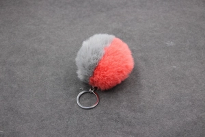 Détail d'un porte-clés en fausse fourrure bicolore gris et rose avec boucle en métal