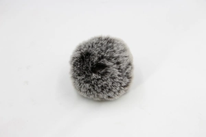 Detail of fluffy two-tone grey and black faux fur pompom showing dense texture