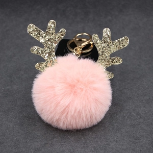 Pink plush ball keychain with glittery golden antlers and metal clasp detail