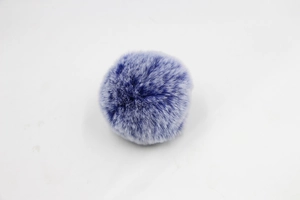 Detail view of a fluffy two-tone purple and blue faux fur pompom for bags and keychains