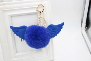 Detailed view of fluffy royal blue faux fur keychain with fabric angel wings and gold clasp