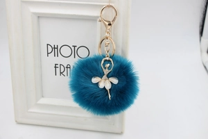 Detail of blue plush fur ball keychain with rhinestone ballerina and golden metal lobster clasp