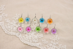 Détail macro de dix breloques en verre faites main avec de vraies fleurs séchées