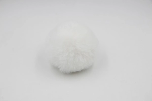 Detailed close-up of a soft white faux fur pompom ball for bags and keychains