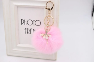 Close-up of pink fluffy ballerina keychain with sparkling crystals and gold hardware
