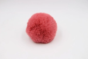 Close-up of a 8cm fluffy dark pink faux rabbit fur pompom for bags and accessories
