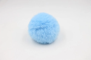 Close-up of a light blue 8cm faux rabbit fur pom pom showing soft synthetic fiber texture