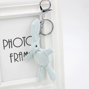 Porte-clés lapin en tissu bleu clair à pois avec clip argenté sur cadre blanc