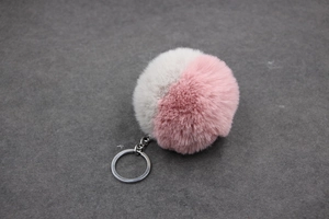 Détail du porte-clés en fausse fourrure bicolore gris et rose avec anneau en métal argenté