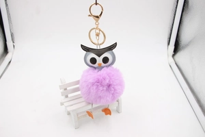 Détail du porte-clés chouette en fausse fourrure avec pompon violet et fermoir doré