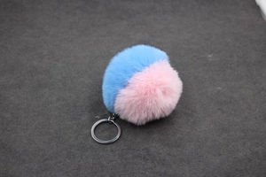 Détail du porte-clés pompon bicolore bleu et rose avec anneau en métal argenté